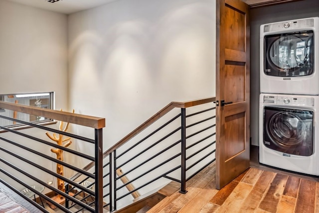 washroom featuring hardwood / wood-style floors and stacked washer / drying machine