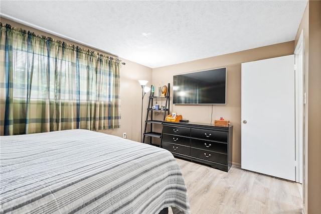 bedroom featuring a textured ceiling and light wood-type flooring