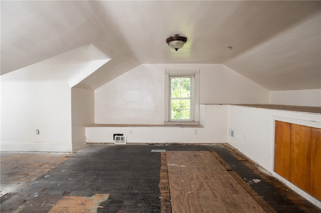 bonus room with dark hardwood / wood-style floors and vaulted ceiling