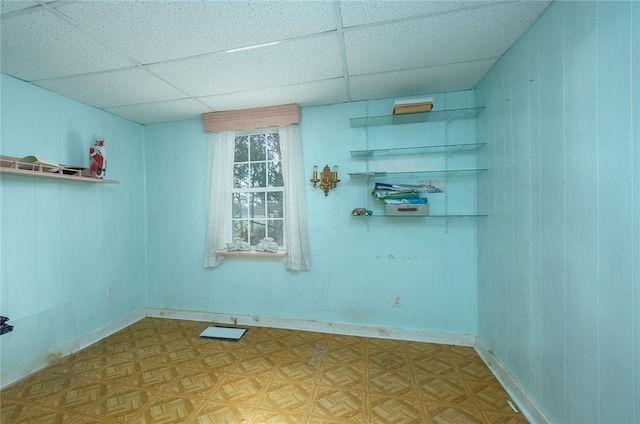 spare room featuring light parquet flooring and a drop ceiling