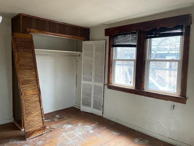 unfurnished bedroom featuring a closet and hardwood / wood-style floors