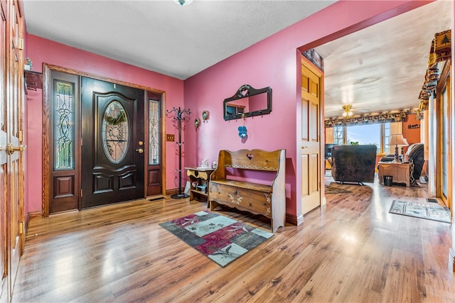 entryway featuring light hardwood / wood-style flooring, ceiling fan, and a textured ceiling