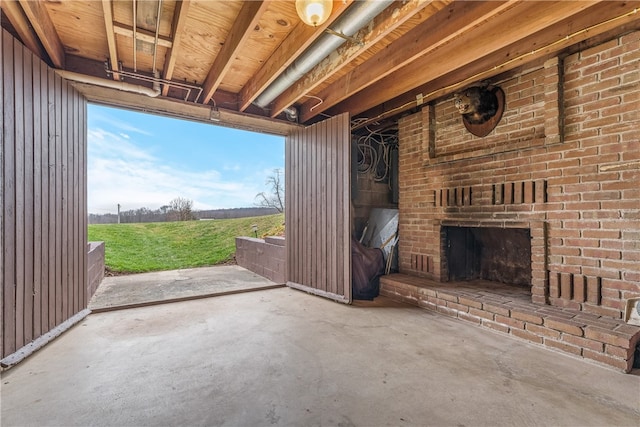 interior space featuring brick wall and an outdoor brick fireplace