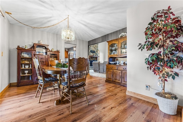 dining area with light hardwood / wood-style flooring and a notable chandelier