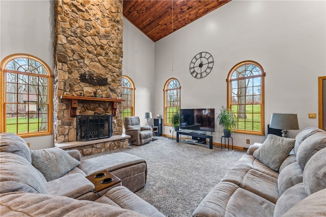 carpeted living room featuring a stone fireplace, high vaulted ceiling, and wooden ceiling