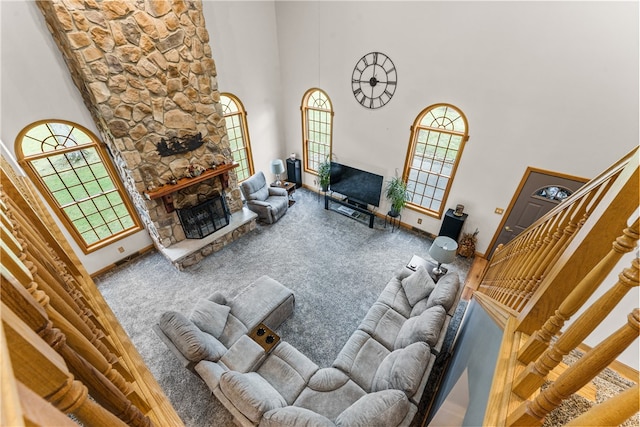 living room featuring carpet, a towering ceiling, and a fireplace