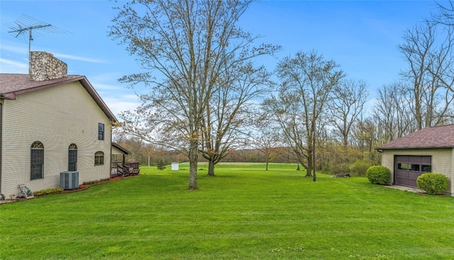 view of yard with central AC and a garage