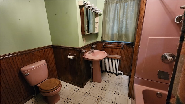 full bathroom featuring tile floors, radiator, toilet, and shower / bathtub combination with curtain