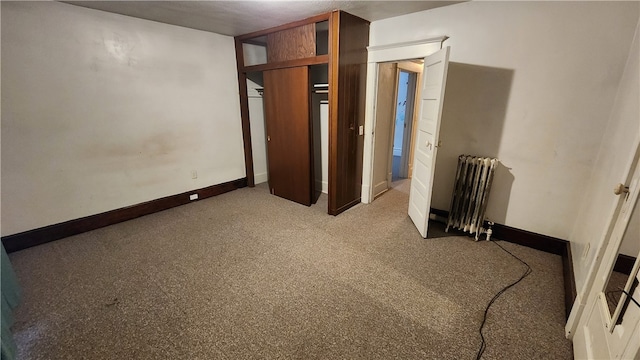 unfurnished bedroom with carpet and radiator