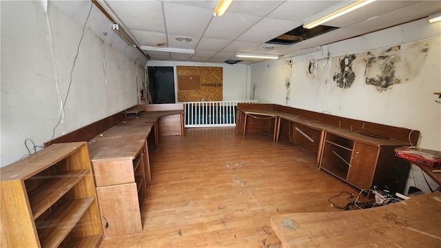 interior space with hardwood / wood-style flooring and a drop ceiling