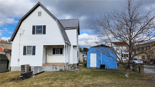 rear view of property with central AC unit, a yard, and an outdoor structure