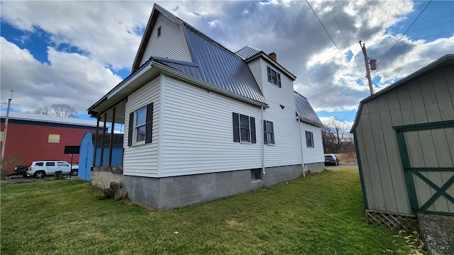 view of home's exterior featuring a storage unit and a lawn