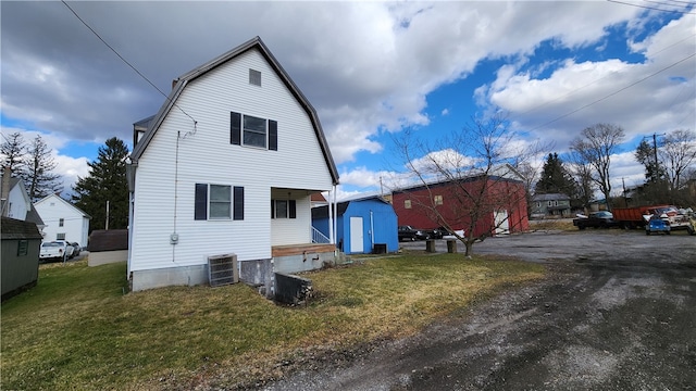 view of front of property with central AC and a front yard