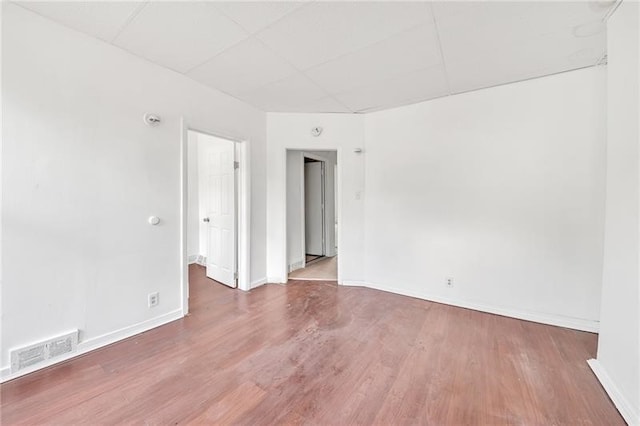 unfurnished room featuring a drop ceiling and wood-type flooring