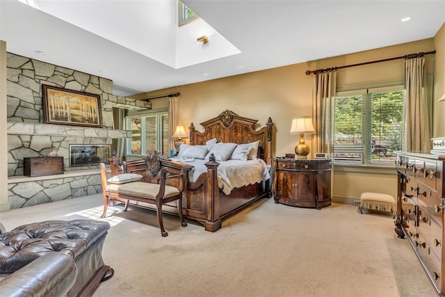 bedroom featuring light colored carpet and a fireplace