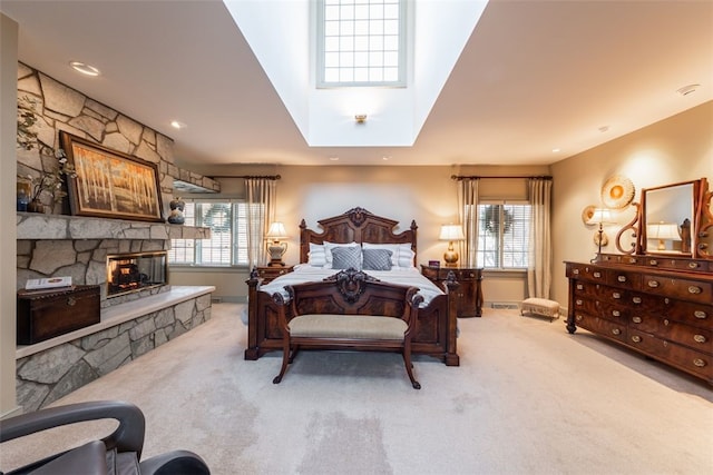 carpeted bedroom featuring a fireplace and multiple windows