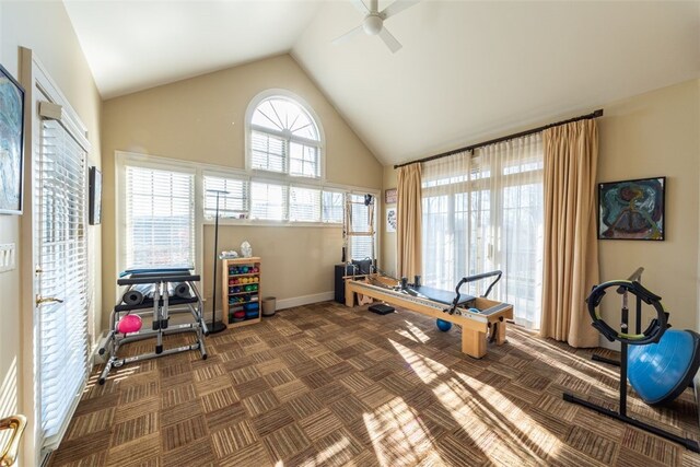 workout room with high vaulted ceiling, ceiling fan, and dark colored carpet