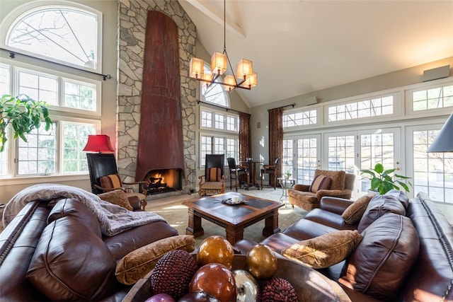 living room with a notable chandelier, a fireplace, and high vaulted ceiling