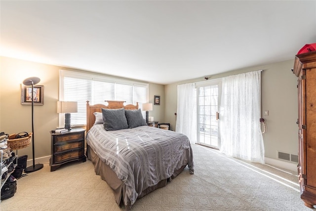 carpeted bedroom featuring access to outside and multiple windows