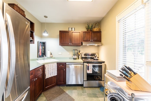 kitchen featuring hanging light fixtures, stainless steel appliances, sink, and light tile floors