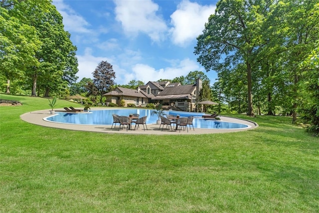 view of swimming pool with a lawn