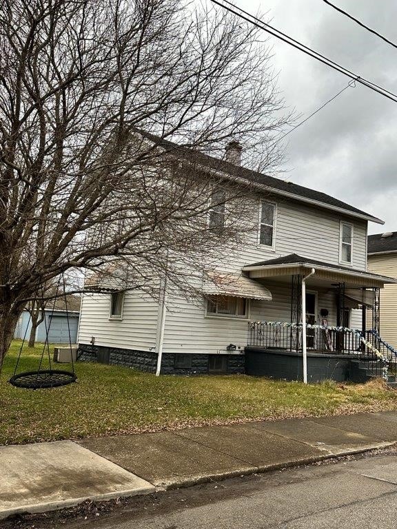 exterior space featuring a porch and a yard