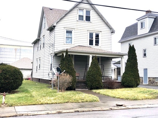 view of property with a front yard and covered porch