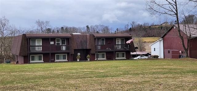 view of front of property with central AC unit, a front lawn, and a balcony