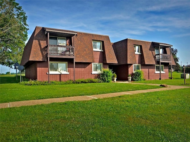 view of front of property with a balcony and a front lawn