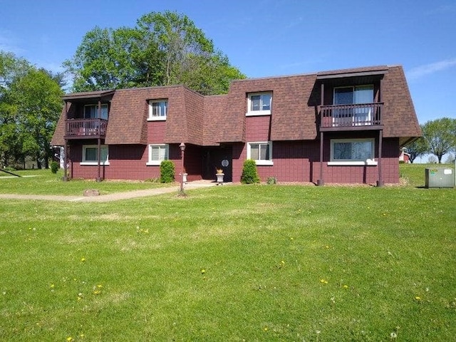 exterior space with a balcony and a lawn