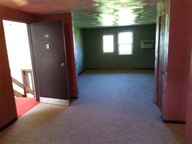 hallway with light colored carpet and a wall mounted AC