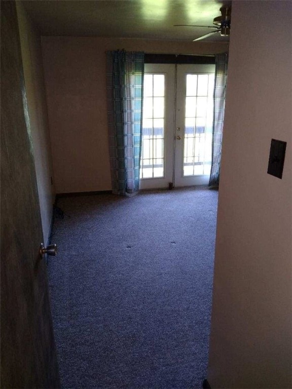 carpeted empty room with ceiling fan and french doors