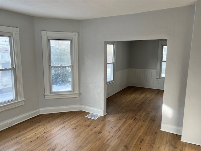 empty room with hardwood / wood-style floors and plenty of natural light