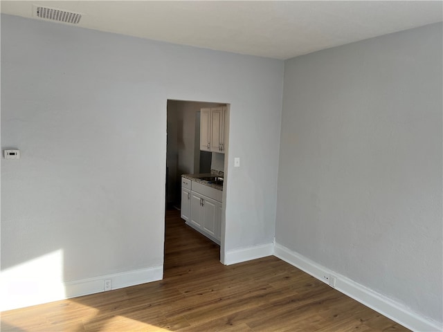 unfurnished room with sink and hardwood / wood-style floors