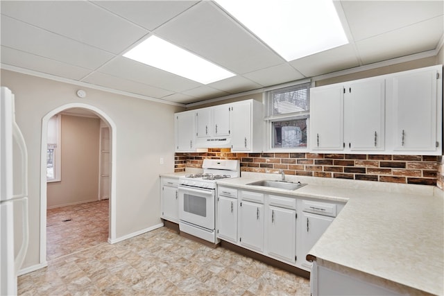 kitchen with white appliances, light tile floors, sink, white cabinetry, and range hood