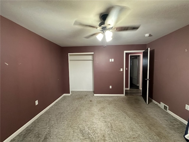 unfurnished room featuring ceiling fan and dark colored carpet