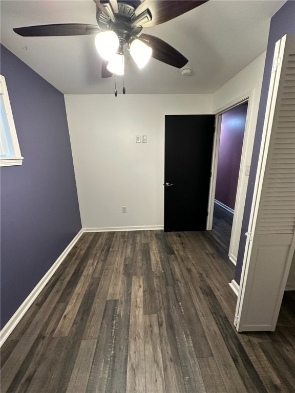 empty room with ceiling fan and dark hardwood / wood-style floors