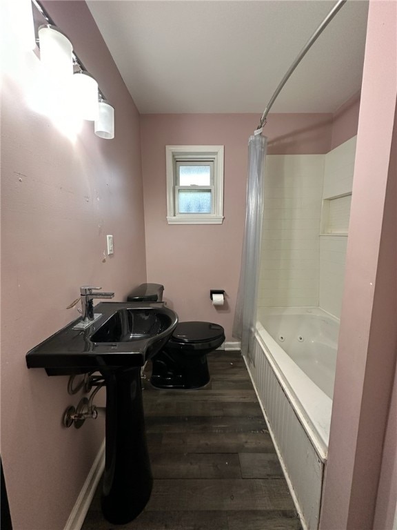 bathroom featuring toilet, shower / tub combo with curtain, and wood-type flooring