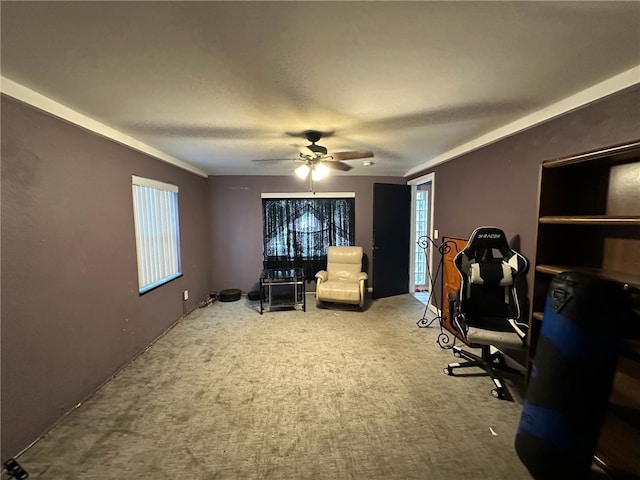 carpeted home office featuring ornamental molding and ceiling fan