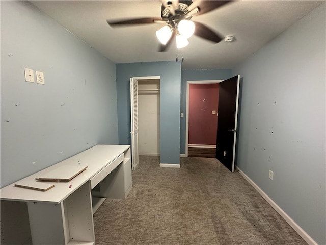 unfurnished bedroom featuring ceiling fan and dark colored carpet