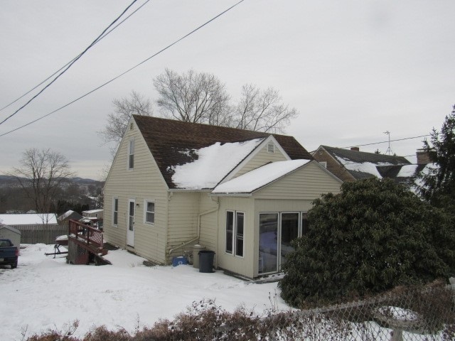 view of snow covered back of property