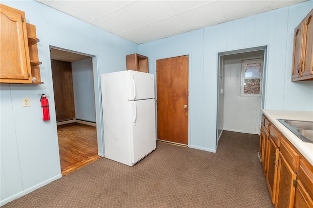 kitchen featuring sink, dark colored carpet, white refrigerator, and a baseboard radiator