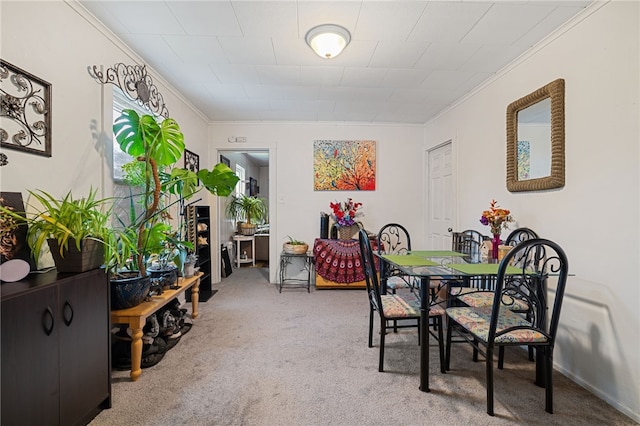 carpeted dining area with ornamental molding