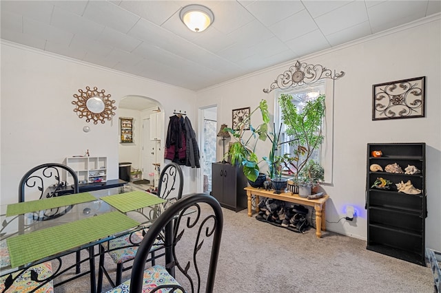 dining room featuring crown molding and light colored carpet