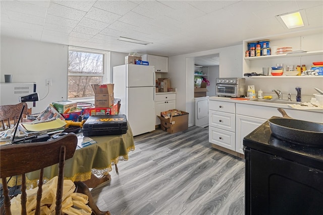 interior space featuring sink, light wood-type flooring, and washer and clothes dryer