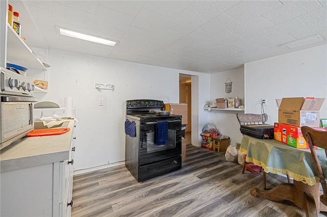 kitchen with dark hardwood / wood-style floors and black range with electric cooktop