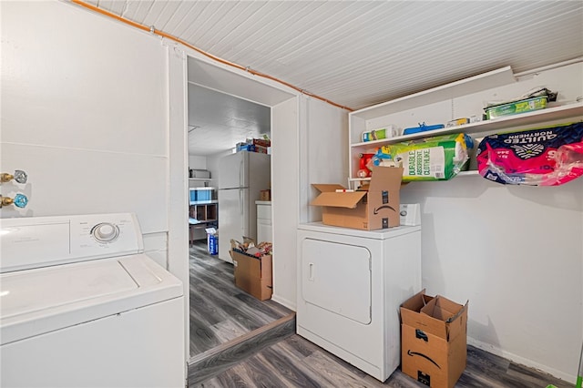 clothes washing area with dark hardwood / wood-style flooring and washer / dryer