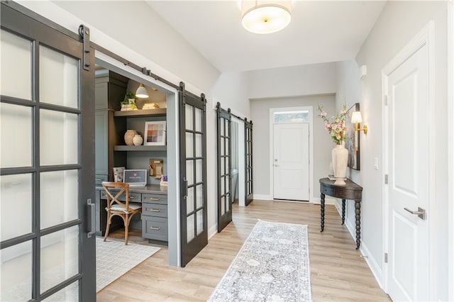 interior space featuring french doors, a barn door, and light wood-type flooring