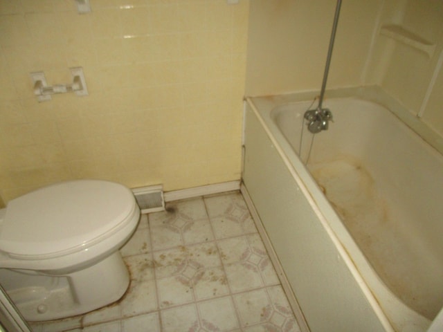 bathroom with toilet and tile floors