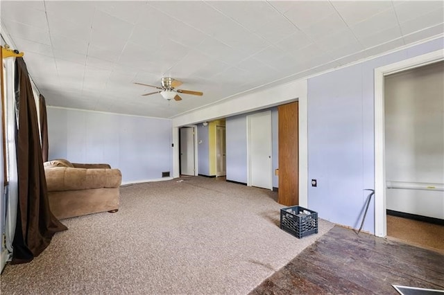 interior space with light colored carpet, ornamental molding, and ceiling fan